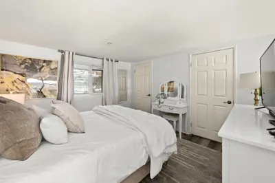 a white bedroom with a bed and a desk at The Italian Retreat, Little Italy in San Diego