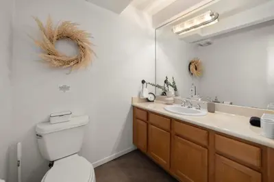 a bathroom with a toilet and a sink and a mirror at The Italian Retreat, Little Italy in San Diego