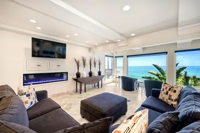 a living room with a couch and a tv at Villa Jules, Oceanfront, Private Beach, Fire Pit in Oceanside