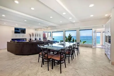 a dining room with a table and chairs and the ocean at Villa Jules, Oceanfront, Private Beach, Fire Pit in Oceanside