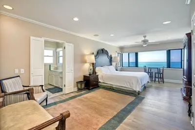 a bedroom with a bed and a table and chairs at Villa Jules, Oceanfront, Private Beach, Fire Pit in Oceanside