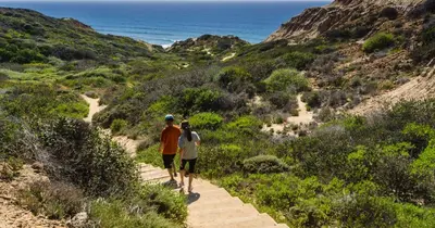 two people walking down a trail near the ocean at Convention close by 2BR Suite Free Parking in San Diego