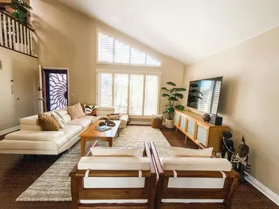 a living room with couches and a large window at Resort style back yard heated pool and spa in Encinitas