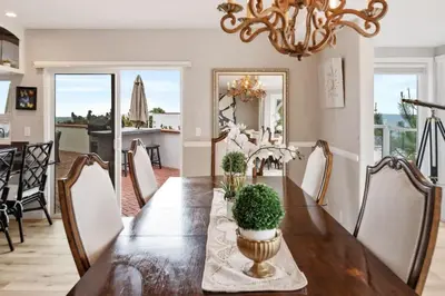 a dining room with a long table and a chandelier at California Dreamin Your Ocean-View Sanctuary in San Diego