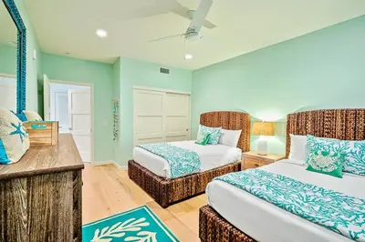 a bedroom with two beds and a chair in it at Stunning Oceanfront Getaway at Windansea Beach in San Diego