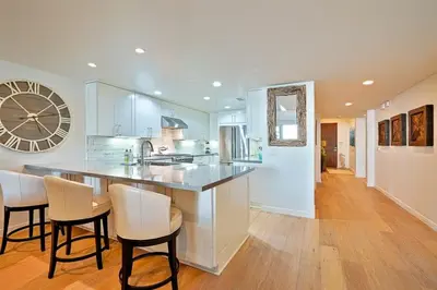 a large kitchen with a large clock on the wall at Stunning Oceanfront Getaway at Windansea Beach in San Diego