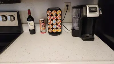 a counter with a bottle of wine and a coffee maker at Centrally Located, 4x Queen, 300 MBPS Internet with Backyard! in Hemet