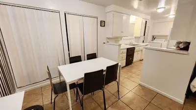a kitchen with a white table and black chairs at Centrally Located, 4x Queen, 300 MBPS Internet with Backyard! in Hemet
