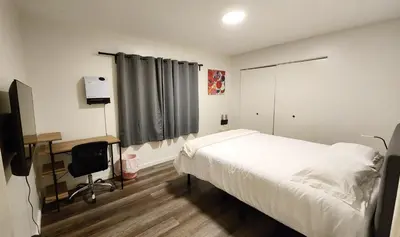 a bedroom with a bed and a desk and a television at Centrally Located, 4x Queen, 300 MBPS Internet with Backyard! in Hemet