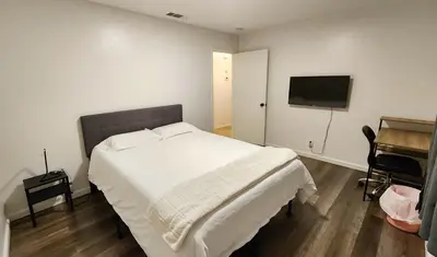 a bedroom with a white bed and a flat screen tv at Centrally Located, 4x Queen, 300 MBPS Internet with Backyard! in Hemet