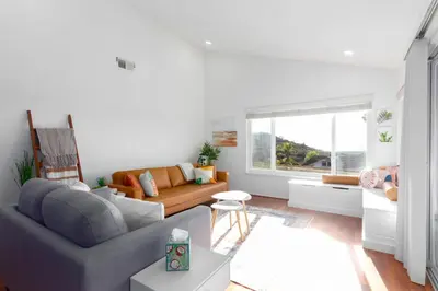 a living room with a couch and a window at Vacation Oasis! Ocean Views~Mini Golf~King-Suites in Solana Beach