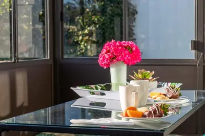 a glass table with plates of food and flowers on it at Vacation Oasis! Ocean Views~Mini Golf~King-Suites in Solana Beach