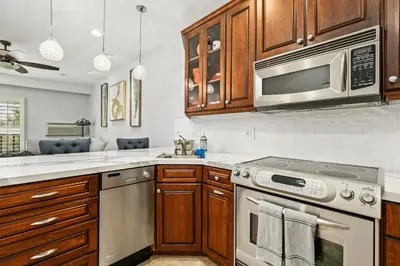 a kitchen with stainless steel appliances and wooden cabinets at 683 Just inside the gates of the Resort - Golf & Premier Fitness Guests Welcome in Encinitas