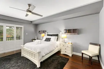 a white bedroom with a white bed and a chair at 689 - Steps to the Resort, Peaceful Studio with free Wifi & Parking in Encinitas