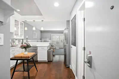 a kitchen with white cabinets and a table with flowers on it at 689 - Steps to the Resort, Peaceful Studio with free Wifi & Parking in Encinitas