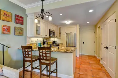 a kitchen with a island with two chairs and a counter at 604 Gorgeous Renovated Condo, Steps to Omni Spa, Golf, Tennis, PFC & Exclusive Building Pool in Encinitas