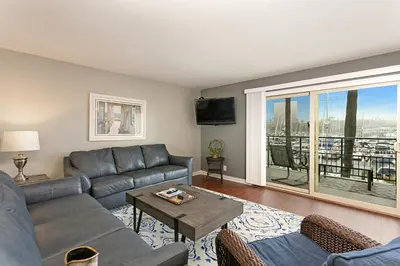 a living room with a couch and a table at 210B Harbor Views Short Stroll to Beach, Large Balcony, Walk to Dining Shops in Oceanside