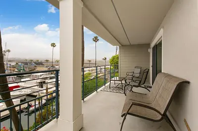 a balcony with chairs and a view of a marina at 210B Harbor Views Short Stroll to Beach, Large Balcony, Walk to Dining Shops in Oceanside