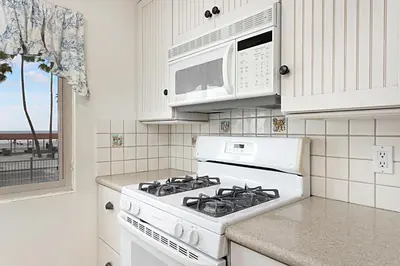 a white stove top oven in a kitchen with a microwave at 212A Beachfront View-Free Wifi in Oceanside
