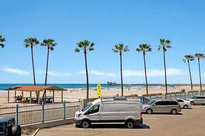 a van parked next to a beach with palm trees at 213A - Take a Beach Break at Marina Del Mar - Beach & Ocean Views in Oceanside
