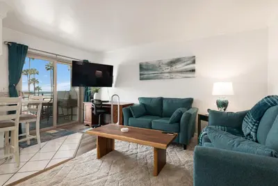 a living room with a couch and a table at 214A - Beach and Water View, Steps to the Sand in Oceanside