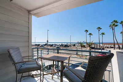 a balcony with a table and chairs and a view of the beach at 214A - Beach and Water View, Steps to the Sand in Oceanside