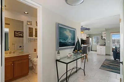 a bathroom with a sink and a toilet and a table at 301B Ocean Harbor View - Top Floor Corner Unit in Oceanside