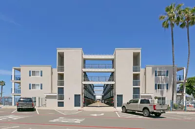 a car parked in a parking lot in front of a building at 301B Ocean Harbor View - Top Floor Corner Unit in Oceanside