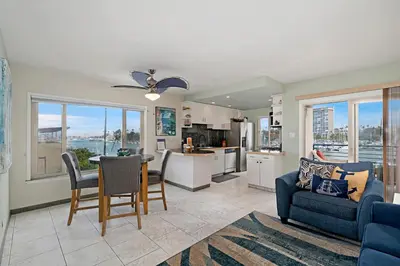 a living room with a blue couch and a kitchen at 301B Ocean Harbor View - Top Floor Corner Unit in Oceanside