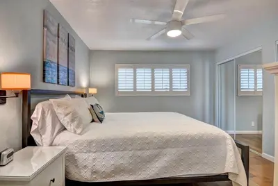 a bedroom with a bed and a ceiling fan at 307B Steps from the sand! Freshly Decorated with Harbor Views in Oceanside