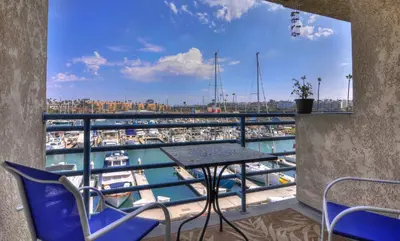 a balcony with a table and chairs and a marina at 307B Steps from the sand! Freshly Decorated with Harbor Views in Oceanside