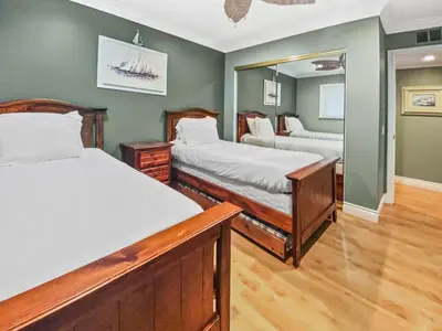 a bedroom with two beds and a mirror at 311B Harbor Views and Steps to the Sand in Oceanside