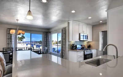 a kitchen with white cabinets and a view of a harbor at 401B Marina Del Mar Penthouse Harbor & Ocean View in Oceanside