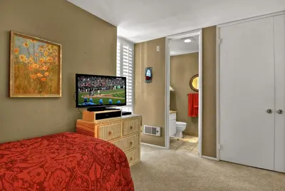 a bedroom with a flat screen tv and a bed at Tropical Water View at North Coast Village C200 in Oceanside