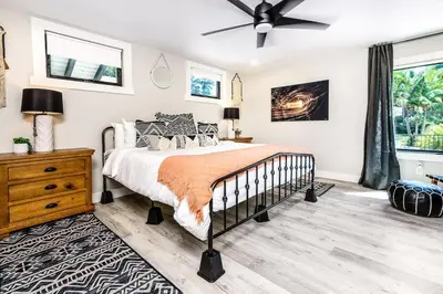 a bedroom with a bed and a ceiling fan at Poppy Cottage in Carlsbad