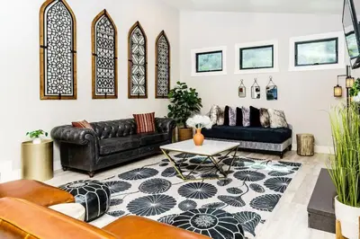 a living room with a leather couch and a table at Poppy Cottage in Carlsbad
