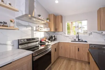 a kitchen with white counter tops and wooden cabinets at Entire house - 4 Bedroom & 2 Bath, 5 Min to Beach in Oceanside