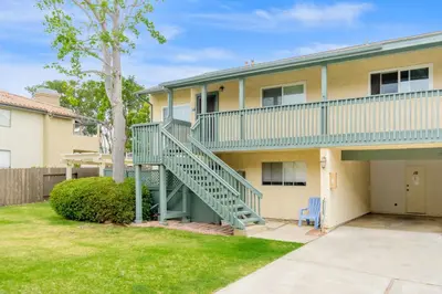a apartment building with a staircase in a yard at Juniper Coastal Home - 30-Night Minimum in Carlsbad