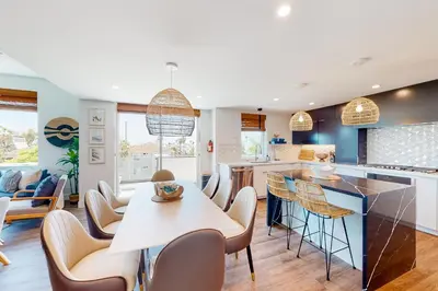 a kitchen and living room with a table and chairs at Seaside Serenity Retreat in Oceanside