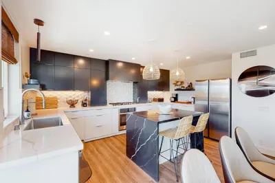 a kitchen with black and white cabinets and a counter at Seaside Serenity Retreat in Oceanside