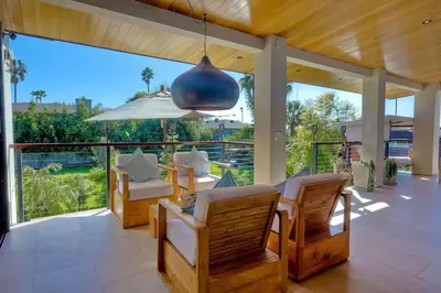 a patio with a table and chairs and a large window at Bali Hai, Luxury, High-End Encinitas Home, Large Outdoor Living Area in Encinitas