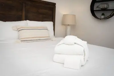a bedroom with a white bed with towels on it at North Park Retreat - Trendy - Tranquil - Vibrant in San Diego
