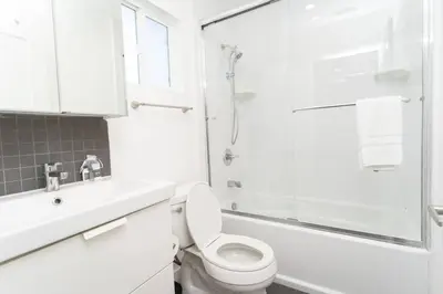 a white bathroom with a toilet and a shower at North Park Retreat - Trendy - Tranquil - Vibrant in San Diego