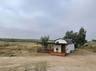 a small building in the middle of a field at Modern wine country barn house in Temecula
