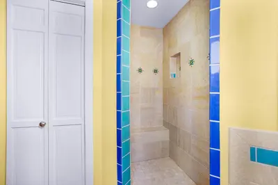 a bathroom with a shower with blue and yellow walls at Spanish Style Cozy Studio in San Diego