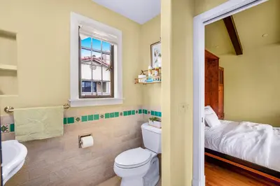 a bathroom with a toilet and a sink and a bed at Spanish Style Cozy Studio in San Diego