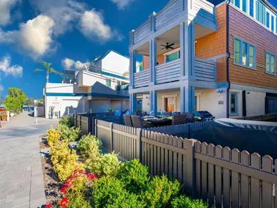 a house with a fence and flowers in front of it at Pristine and Luxe, Steps to Mission Beach and Bay! in San Diego