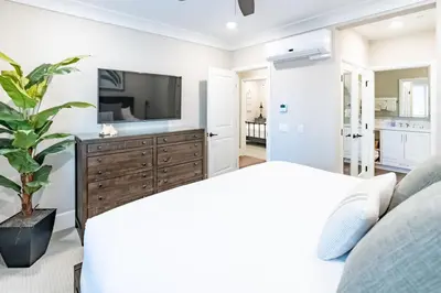 a bedroom with a bed and a tv on a wall at Pristine and Luxe, Steps to Mission Beach and Bay! in San Diego
