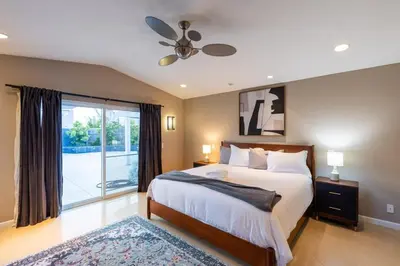 a bedroom with a bed and a ceiling fan at Sumptuous Coastal Hideaway in Oceanside