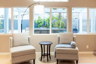 two chairs and a table in a room with windows at Sumptuous Coastal Hideaway in Oceanside